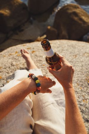 Woman relaxing and drinking beer at beach