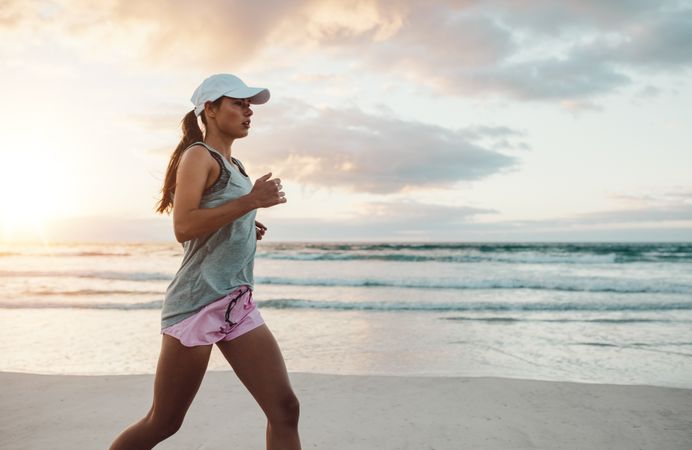 Beautiful young woman jogging on beach