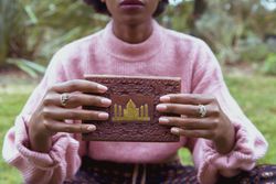 Woman in pink sweater showing a brown book