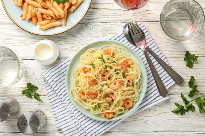 Composition with plate of tasty pasta with shrimps on wooden background