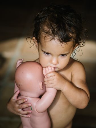 small girl playing with baby doll