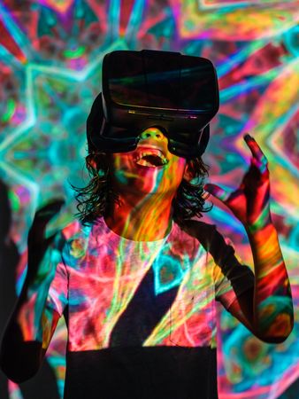 Cheerful boy in VR headset in neon lights