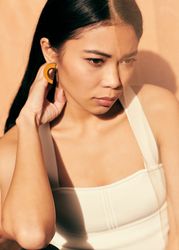 Young woman looking down and resting her hand on her neck