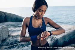 Female runner checking fitness progress on her smart watch 4AJyqb