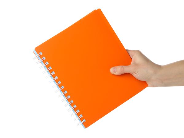 Hand holding orange notebook