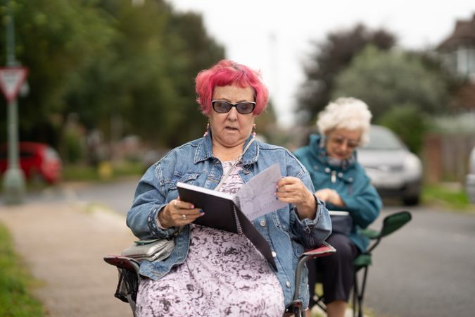 Woman with pink hair sitting outside in drawing class