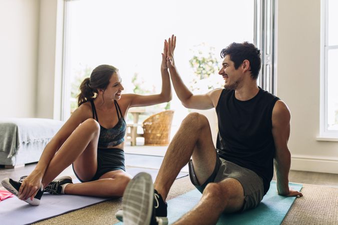 Couple giving each other high five after a successful workout together