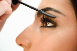 Woman having mascara applied by a professional