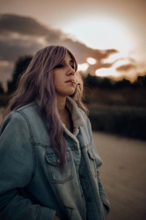 Smoking trendy woman in autumn nature