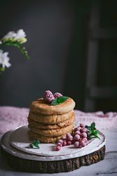 Pile of raspberry pancakes with honey on plate