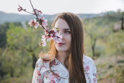 Young happy woman between trees in garden