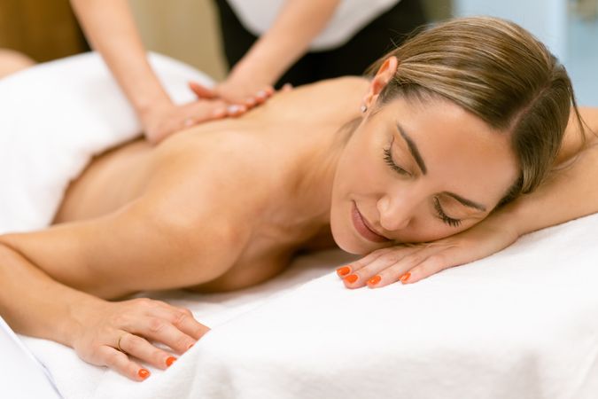 Woman enjoying a relaxing massage at the spa with eyes closed