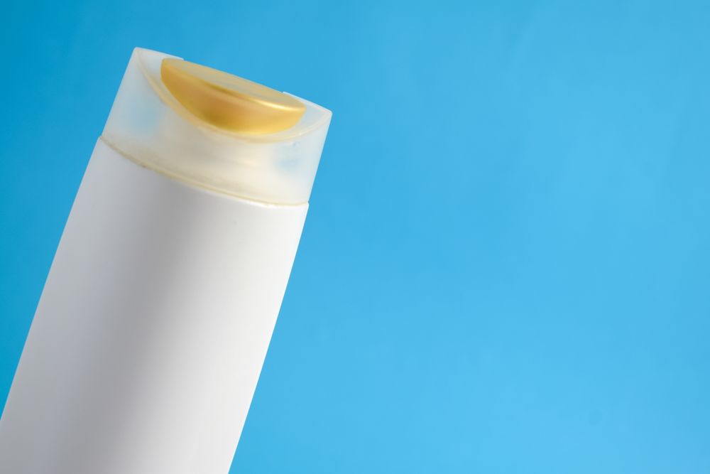 Top up of bottle of body wash or shampoo with blue background