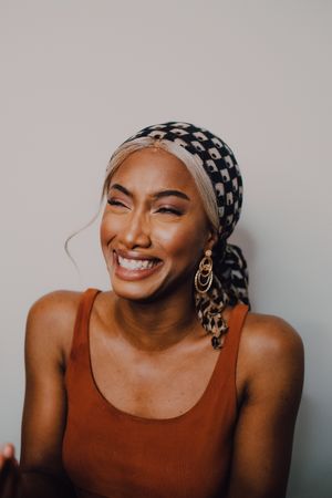 Black woman wearing headscarf and brown dress