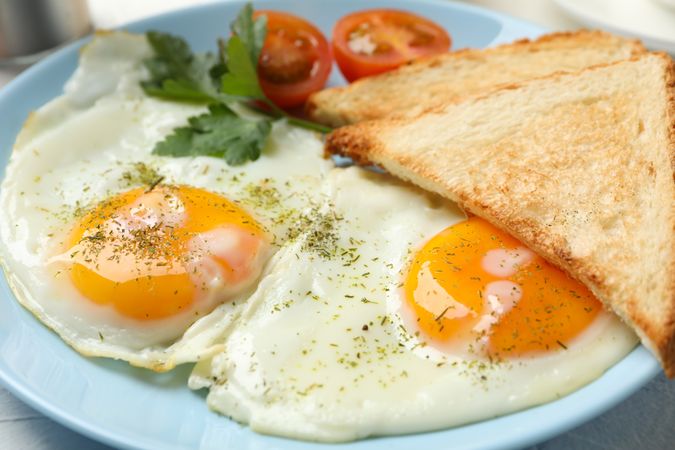 Blue plate with two sunny side up eggs and toast