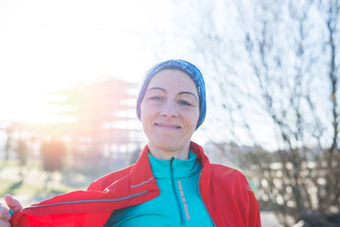 Smiling woman in ear warmers outdoors on sunny fall day
