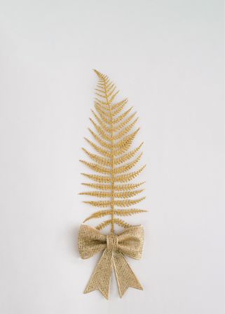 Golden leaf with bow on plain background