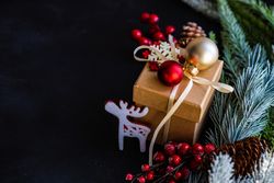 Christmas present with baubles and surrounded by pine branch