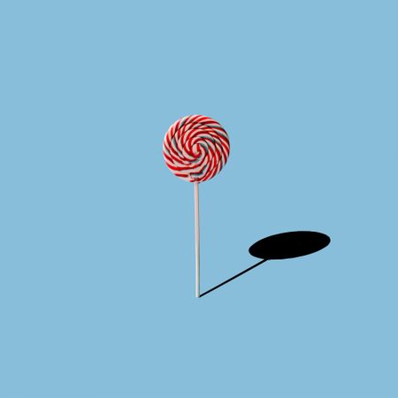 Lollipop and shadow on blue background