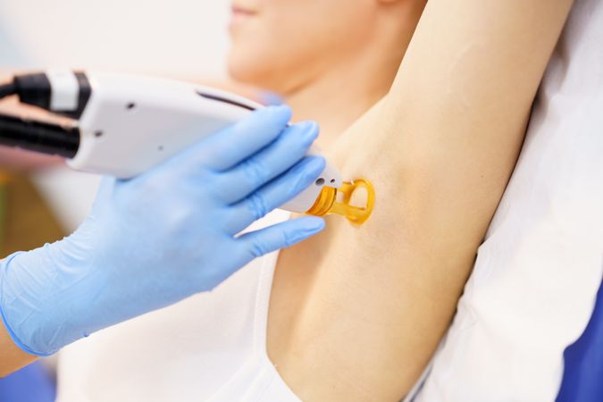 Female receiving underarm laser hair removal at a beauty salon