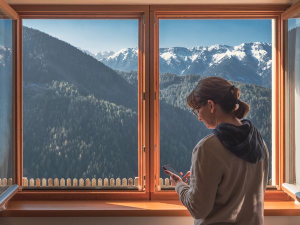 Woman browsing smartphone near window