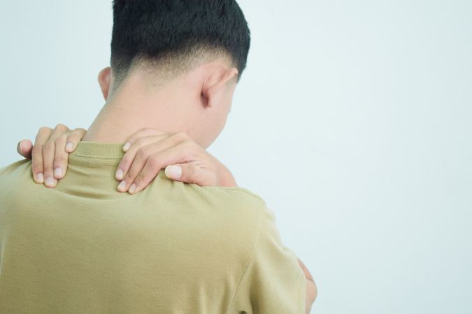 Asian young man touching neck in pain