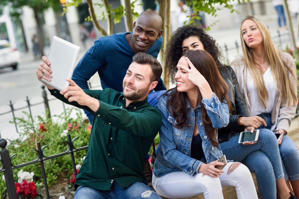 Women and men smiling taking a photo wearing casual clothes