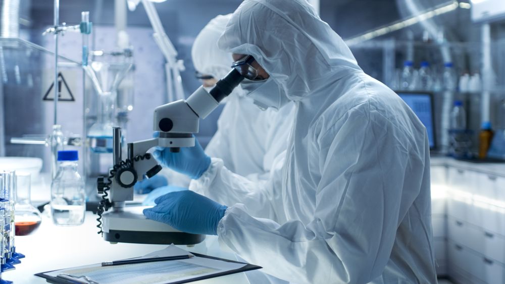 In a Secure High Level Laboratory Scientists in a Coverall Conducting a Research.