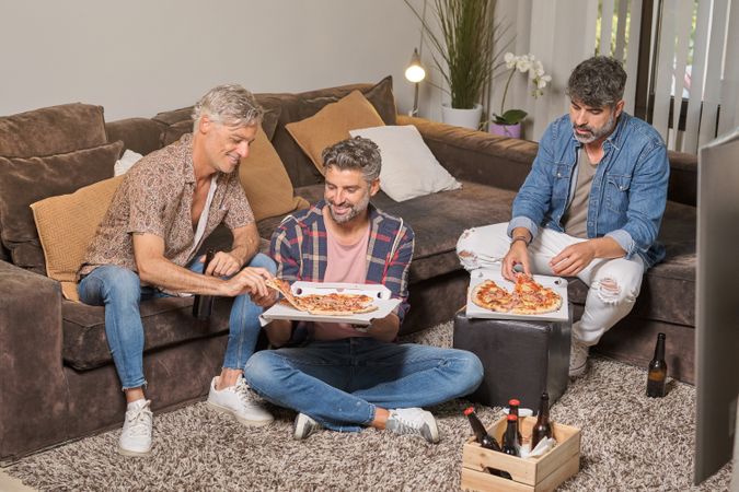 Group of friends eating pizza at home