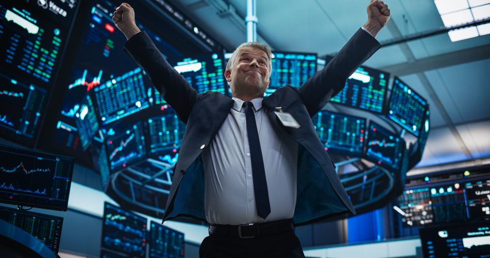 Stock Market Day Trader Working at an Exchange Office with Multi-Monitor Setup with Real-Time Investment, Commodities and Foreign Funds Charts.