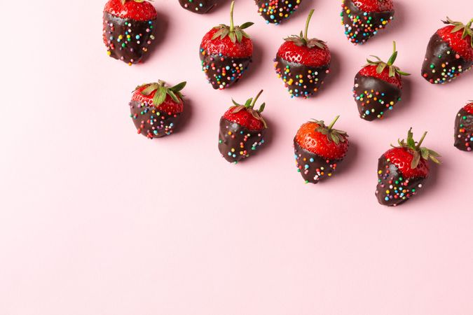 Chocolate fondue. Flat lay with strawberry in chocolate on pink background