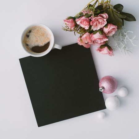 Coffee, decorations and dark paper card with flowers