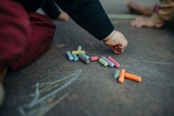 Close up of child’s hands drawing with chalk