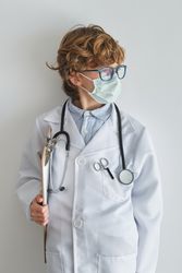 Boy doctor in sterile mask and medical robe