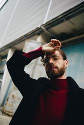 Young handsome white male model wearing turtleneck and glasses with hand to head in swooning pose
