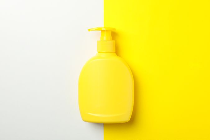 Blank bottle for soap on two tone background, space for text
