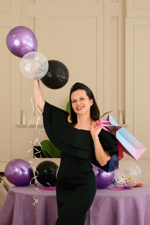 Woman in a dress holding balloons