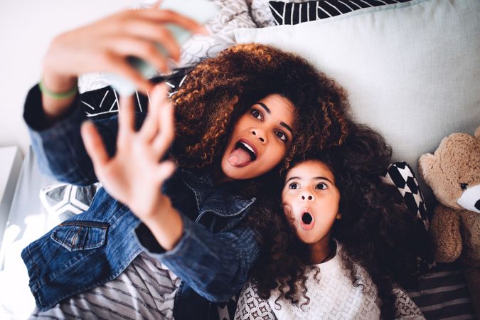 Mother and daughter making a silly face as they take a selfie together