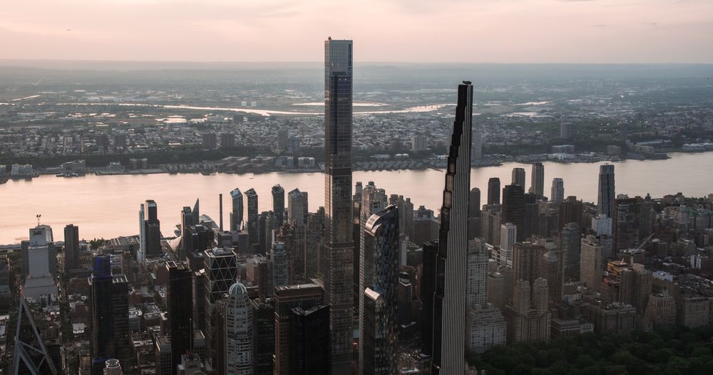 New York City Aerial Evening Cityscape with Stunning Manhattan Landmarks, Skyscrapers and Residential Buildings. Long Wide Angle Panoramic Helicopter View of a Popular Travel Destination