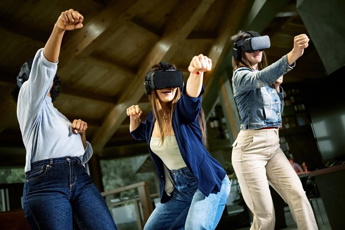 Group of young women using virtual reality headset