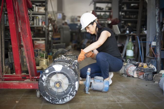Woman fixing turbo in workshop