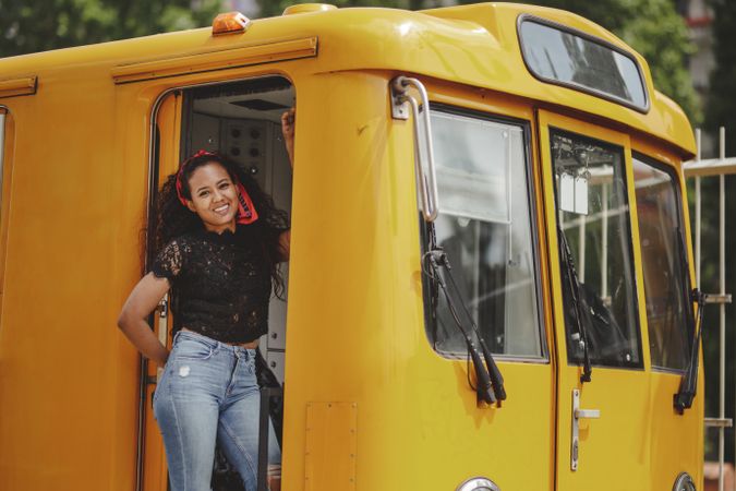 Cheerful hispanic woman standing on train in drivers cabin
