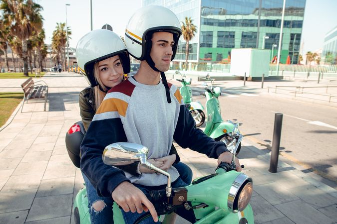 Couple sitting on scooter and talking
