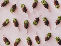 Ice cream chocolate pistachio popsicles, pink background
