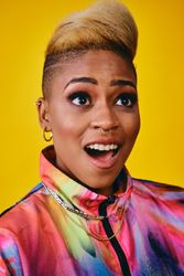 Surprised Black woman in bright 80s windbreaker jacket in yellow studio