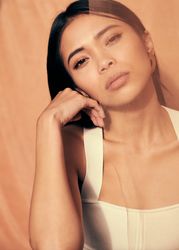 Young woman looking at camera and resting her head on her hand