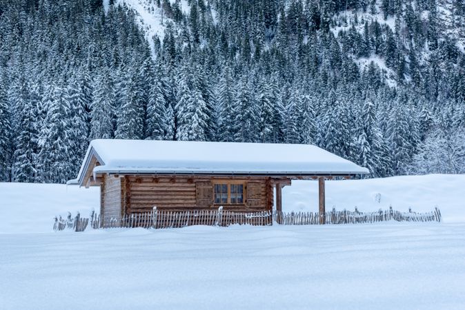 Snow-covered log cabin in deep snow landscape in Bavaria, Germany