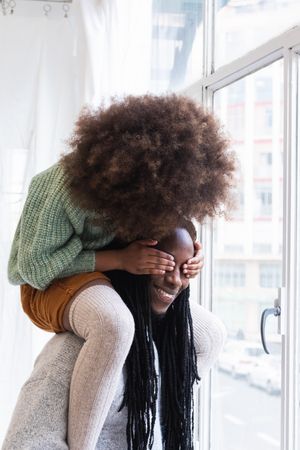 Black girl playing game with father and laughing happily