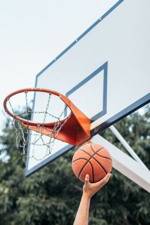 Close-Up of Hand Holding Basketball Near the Hoop