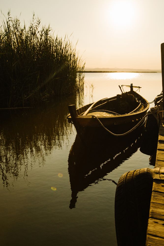 Moored boat by wooden pier